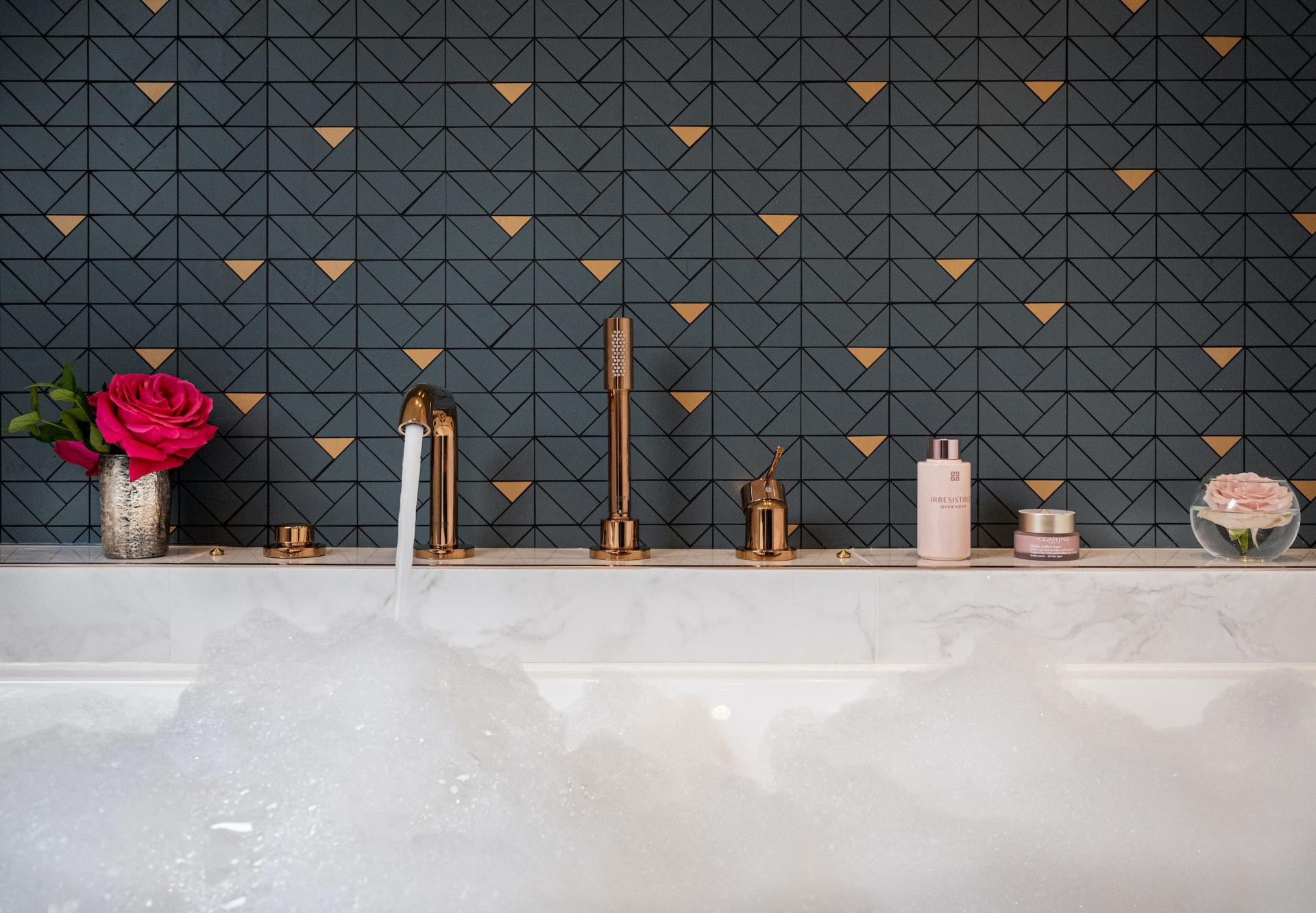 Bañera elegante con productos premium en el hotel boutique Le Tourville en París 